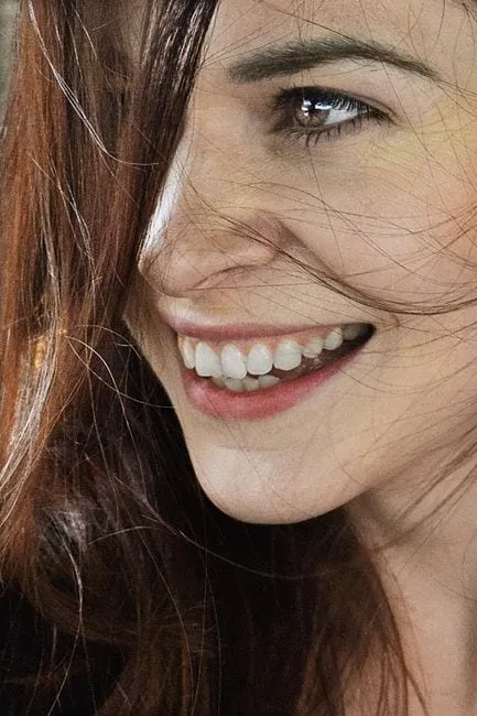 A woman with a bright, natural, healthy smile