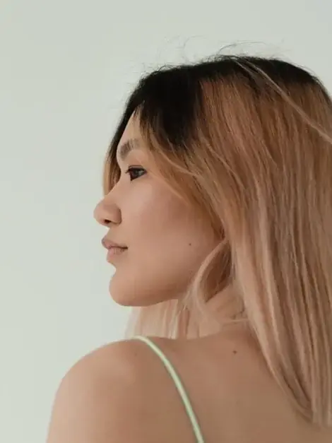 Close-up of a client with sunlit, hand-painted balayage in soft caramel tones