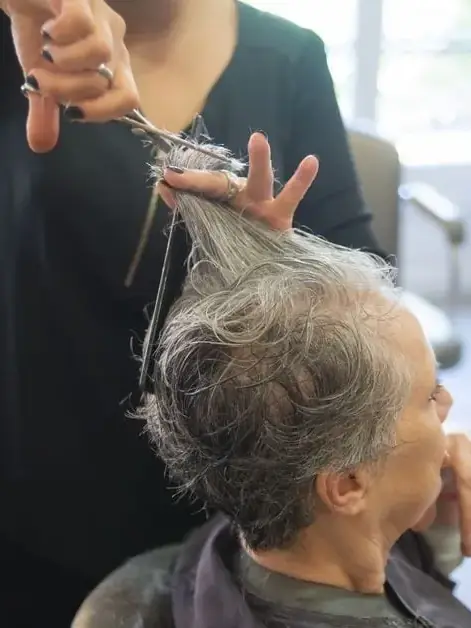 A Lumière stylist cutting a client's hair with precision scissors
