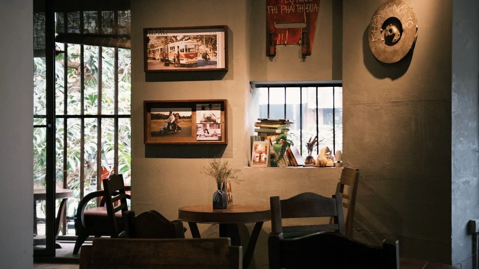 Cosy, warm interior of The Daily Grind café — framed pictures on the wall and soft light through the window